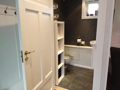 a bathroom with a toilet and a white door at Huset på hauen in Volda