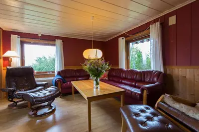a living room with leather couches and a coffee table at Lille Randklev Gæstehus in Ringebu