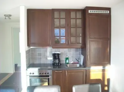 a kitchen with wooden cabinets and a stove and a sink at Røldal Overnatting in Røldal