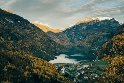 a view of a mountain valley with a town and a lake at Hotel Union Geiranger Bad & Spa in Geiranger