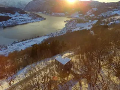 a view of a river and a building in the snow at Hardanger Panorama Lodge in Ulvik