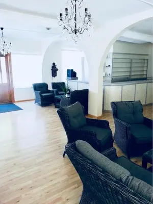 a living room with couches and chairs and a chandelier at Gudvangen Budget Hotel in Gudvangen