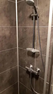 a shower with a shower head in a bathroom at Gudvangen Budget Hotel in Gudvangen