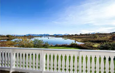 a view of a lake from a white fence at 5 Bedroom Gorgeous Home In Fjørtoft in Fjørtoft