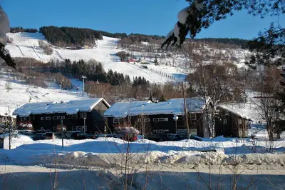 a building with snow on top of it in the snow at Hafjell Alpinlandsby Pluss in Hafjell