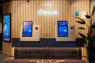 a ticket counter with three cell phones on the wall at Citybox Bergen Danmarksplass in Bergen