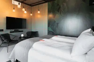 a bedroom with a large white bed with a flat screen tv at Citybox Bergen Danmarksplass in Bergen