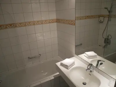 a bathroom with a sink and a shower and a tub at Dreges Hotell - by Classic Norway Hotels in Stranda