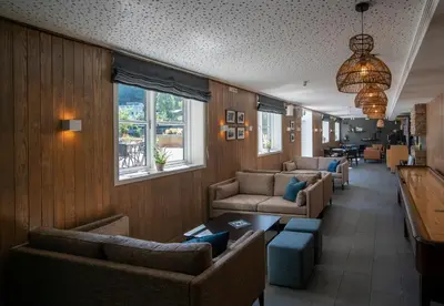 a waiting room with couches and tables and windows at Dreges Hotell - by Classic Norway Hotels in Stranda
