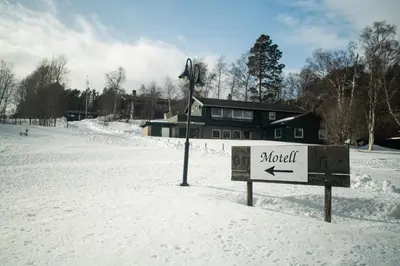 a sign in the snow in front of a house at Dombåstun Motel in Dombås