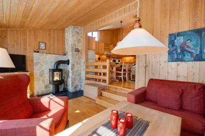 a living room with a couch and a table and a fireplace at Bitigrenda I in Beitostøl