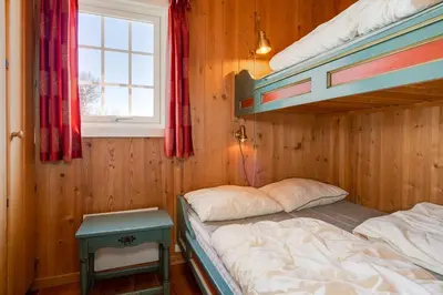 a bedroom with two bunk beds and a window at Bitigrenda I in Beitostøl