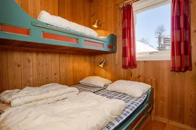 two bunk beds in a room with a window at Bitigrenda I in Beitostøl