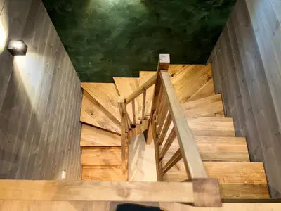 a wooden staircase in a building with a green ceiling at Brekke Gard Hostel in Flåm