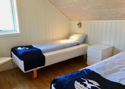 a small room with two beds and a window at Hindrum Fjordsenter in Vannvikan