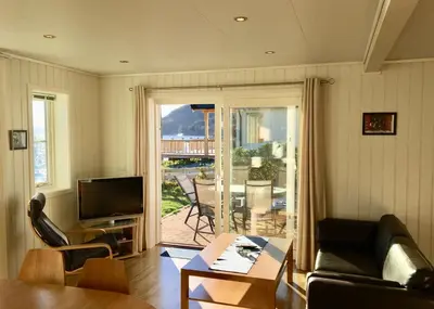 a living room with a couch and a table and a television at Hindrum Fjordsenter in Vannvikan