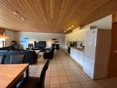 a kitchen and living room with a couch and a refrigerator at Hafjell Grenda lejligheder og hytter in Hafjell