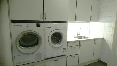 a white kitchen with a washing machine and a sink at Otnes Sør - Luxury 140m2 in Aurland