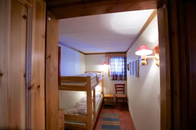 a small room with two bunk beds and a hallway at Ideal For Families 6 Bedrooms, Hot Tub And Sauna in Beitostøl