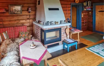 a living room with a fireplace and a table at Three-Bedroom Holiday Home In Sjusjoen in Sjusjøen