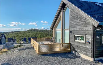 a log cabin with a large window and a deck at 3 Bedroom Beautiful Home In Sjusjøen in Sjusjøen