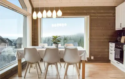 a dining room with a table and chairs and a large window at 3 Bedroom Beautiful Home In Sjusjøen in Sjusjøen
