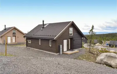a house with a black roof on a gravel driveway at 3 Bedroom Beautiful Home In Sjusjøen in Sjusjøen