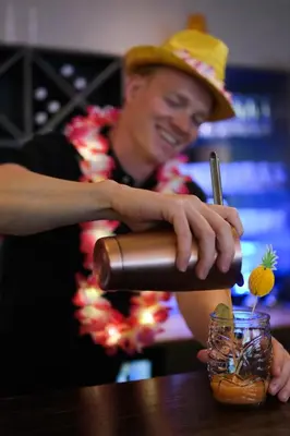 a man in a hat is making a drink at Klingenberg Hotel - Årdal in Årdalstangen