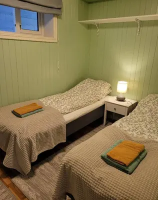 a bedroom with two beds and a lamp on a table at Irenegarden - Panorama apartment in Lauvstad