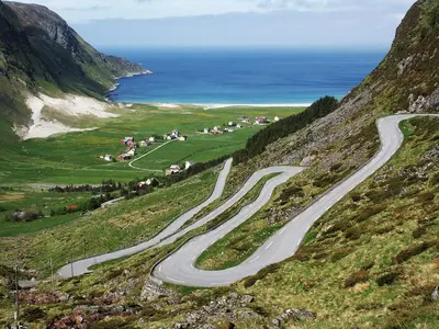 a winding road on a hill next to the ocean at Irenegarden - Panorama apartment in Lauvstad