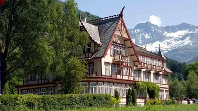 a large building with a mountain in the background at Irenegarden - Panorama apartment in Lauvstad