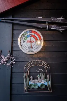 a sign on the side of a building with a clock at Supersentralt ski inn ski out in Geilo