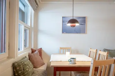 a dining room with a table and a lamp at Supersentralt ski inn ski out in Geilo