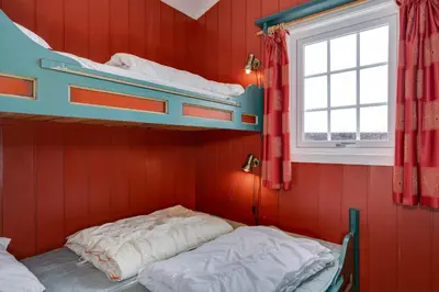 a bedroom with two bunk beds and a window at Bitigrenda B in Beitostøl