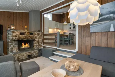 a living room with a fireplace and a table at Bitigrenda G in Beitostøl