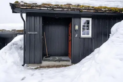 a black shed with a door in the snow at Bitigrenda F in Beitostøl