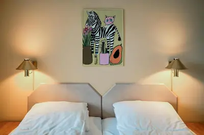 a bedroom with two beds and a painting on the wall at Balestrand Hotel in Balestrand