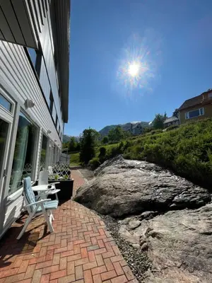 a bench sitting on a brick walkway next to a house at Balestrand Hotel in Balestrand