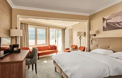 a hotel room with a large bed and a desk at Hotel Ullensvang in Lofthus