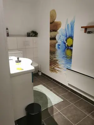a bathroom with a sink and a painting of a blue flower at Apartment Dreamvalley in Isfjorden