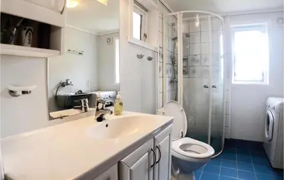 a bathroom with a sink and a toilet and a shower at Gorgeous Home In Norheimsund With Wifi in Norheimsund