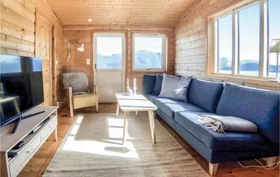 a living room with a blue couch and a table at Gorgeous Home In Norheimsund With Wifi in Norheimsund