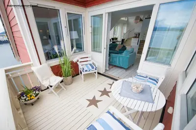 a screened in porch with chairs and a table at Kalvåg Holidayapartment in Kalvåg