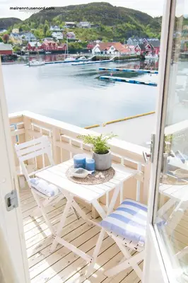 a table on a balcony with a view of the water at Kalvåg Holidayapartment in Kalvåg