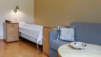 a room with a bed and a couch and a table at Unicare Røros in Røros