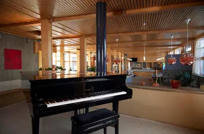 a black piano in a room with a bar at Unicare Røros in Røros