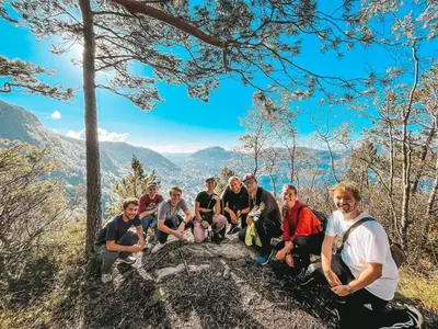 a group of people sitting on a rock in the mountains at Bergen Hostel Montana in Bergen