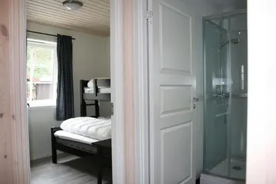 a bathroom with a shower and a glass door at Tråsåvika Camping in Viggja