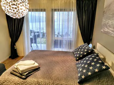 a bedroom with a bed with pillows and a window at Bjørnestrand Fjordside View in Bergen