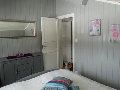 a bedroom with a bed and a dresser and a mirror at Haglebu Feriesenter in Eggedal